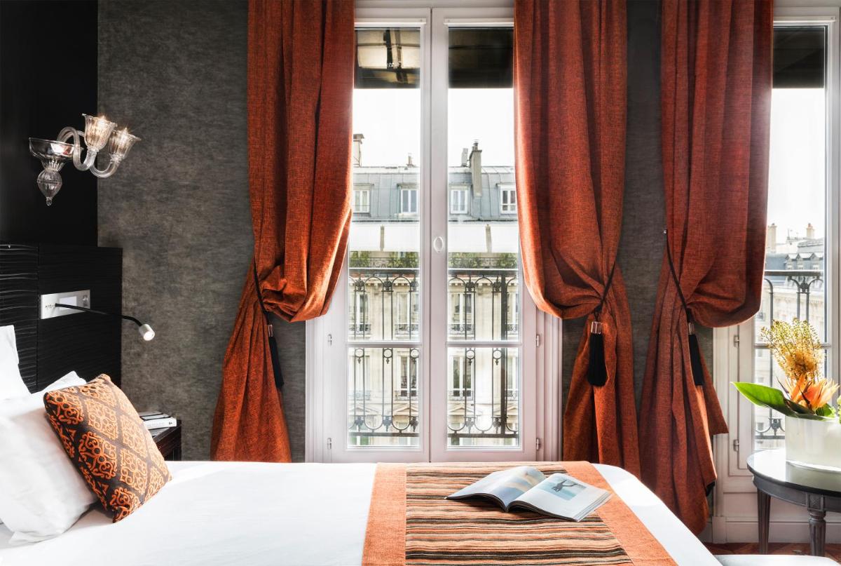 une chambre avec un lit et une grande fenêtre dans l'établissement Maison Albar- Le Champs-Elysées, à Paris
