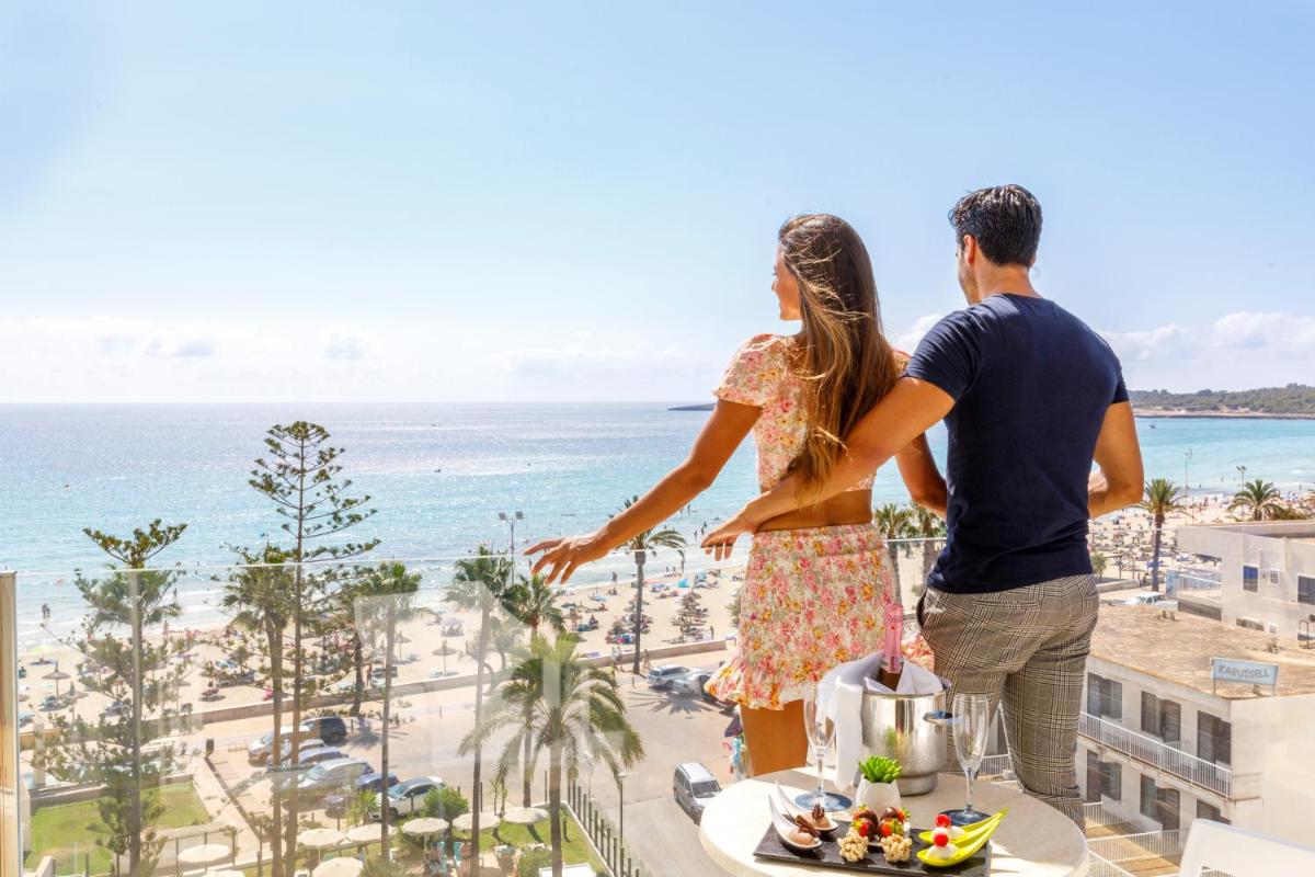 Un hombre y una mujer de pie en un balcón con vistas a la playa. en CM Playa del Moro, en Cala Millor 31 fotos más