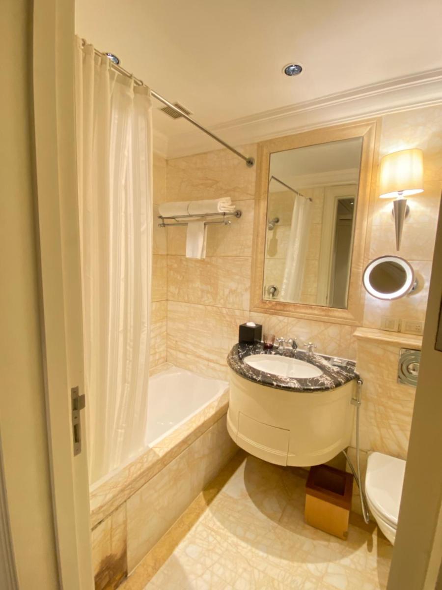 a bathroom with a sink and a tub and a toilet at The Claridges New Delhi in New Delhi a bathroom with a sink and a tub and a toilet at The Claridges New Delhi in New Delhi