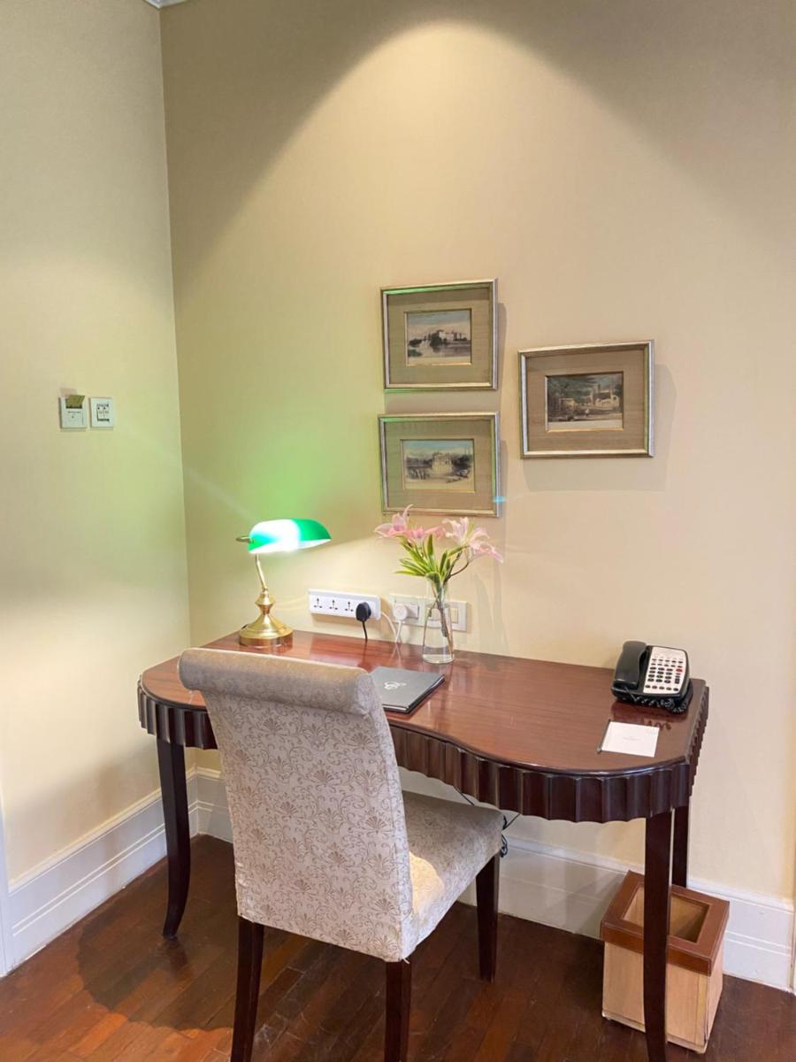 a wooden table with a phone and a desk at The Claridges New Delhi in New Delhi a wooden table with a phone and a desk at The Claridges New Delhi in New Delhi