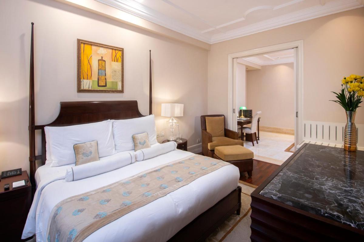 a bedroom with a large bed and a living room at The Claridges New Delhi in New Delhi a bedroom with a large bed and a living room at The Claridges New Delhi in New Delhi