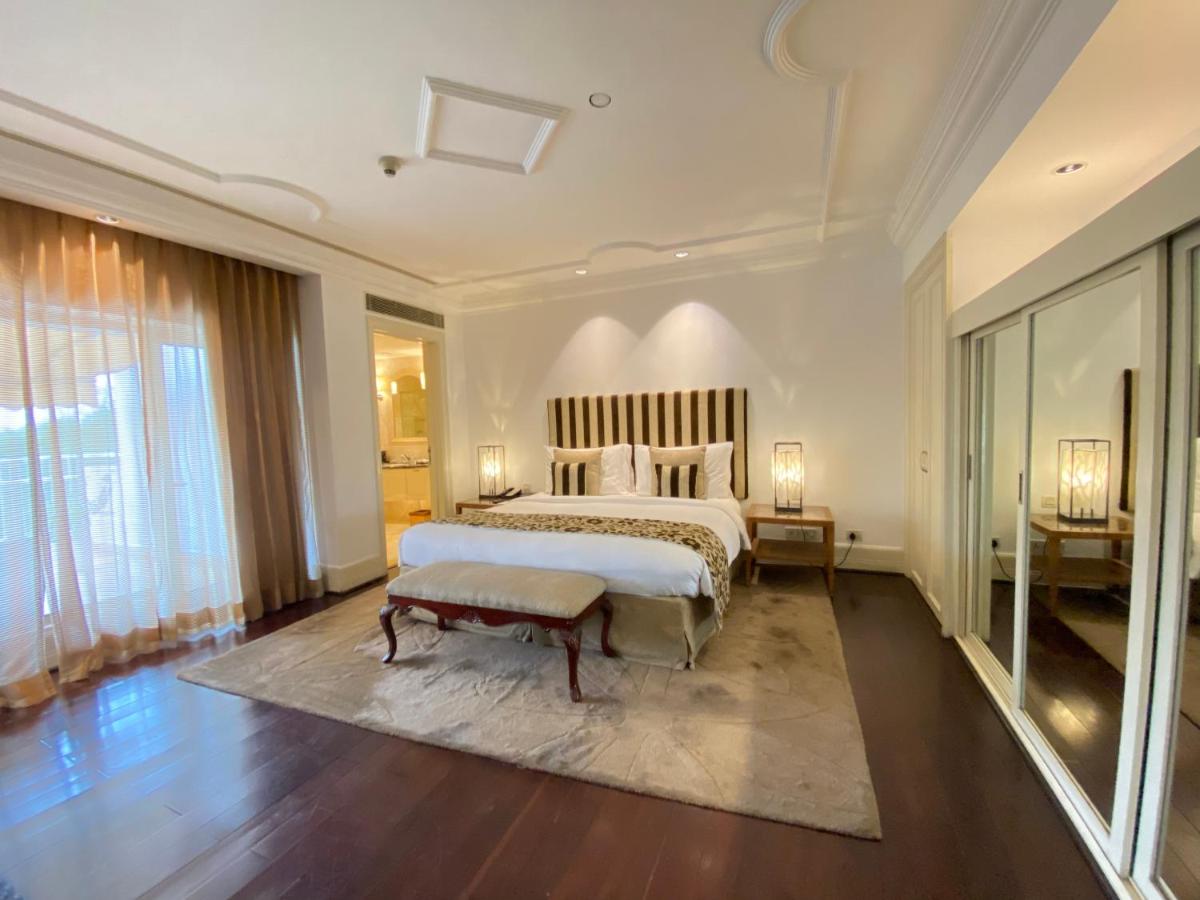 a large bedroom with a bed and a large window at The Claridges New Delhi in New Delhi a large bedroom with a bed and a large window at The Claridges New Delhi in New Delhi