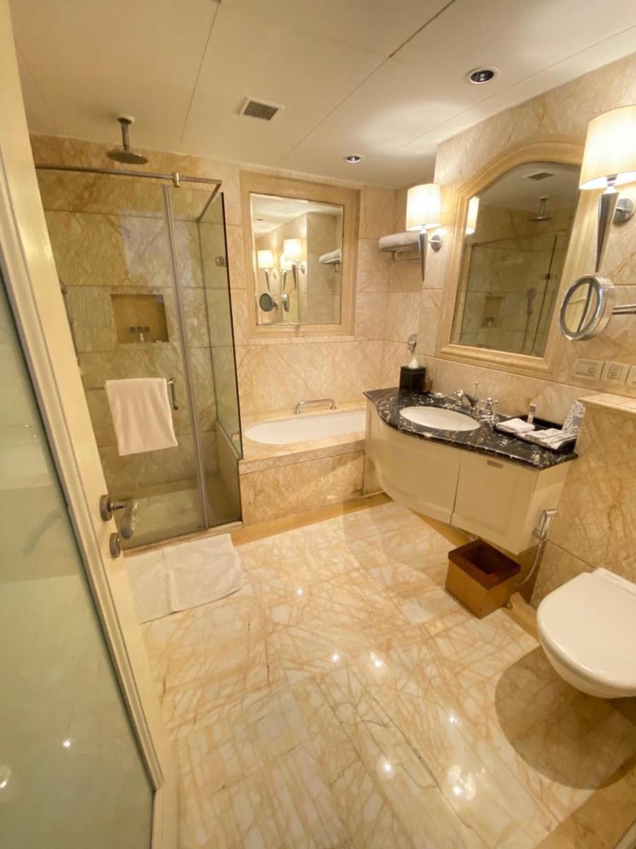 a bathroom with a sink and a shower and a toilet at The Claridges New Delhi in New Delhi a bathroom with a sink and a shower and a toilet at The Claridges New Delhi in New Delhi