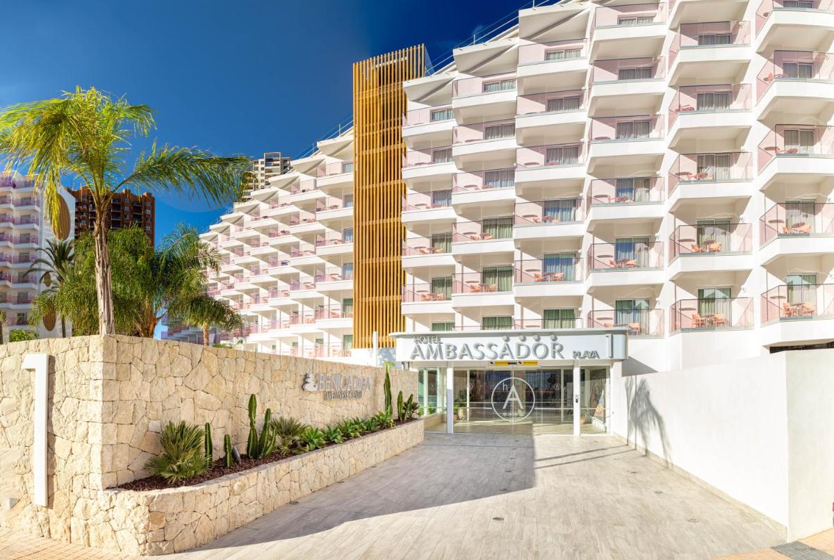 Un gran edificio blanco con palmeras delante. en Ambassador Playa I, en Benidorm