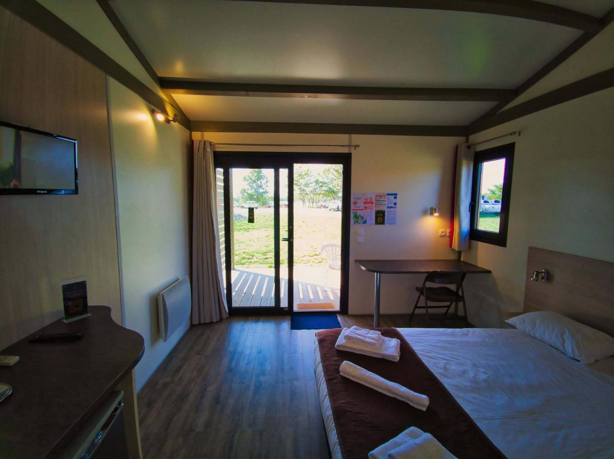 une chambre d'hôtel avec un lit, un bureau et une table dans l'établissement Lodge Hôtel & Spa Les Voiles du Grand Large, à Meyzieu