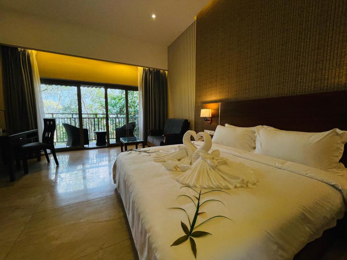a hotel room with a bed with a swan on it at Elephant Passage in Munnar