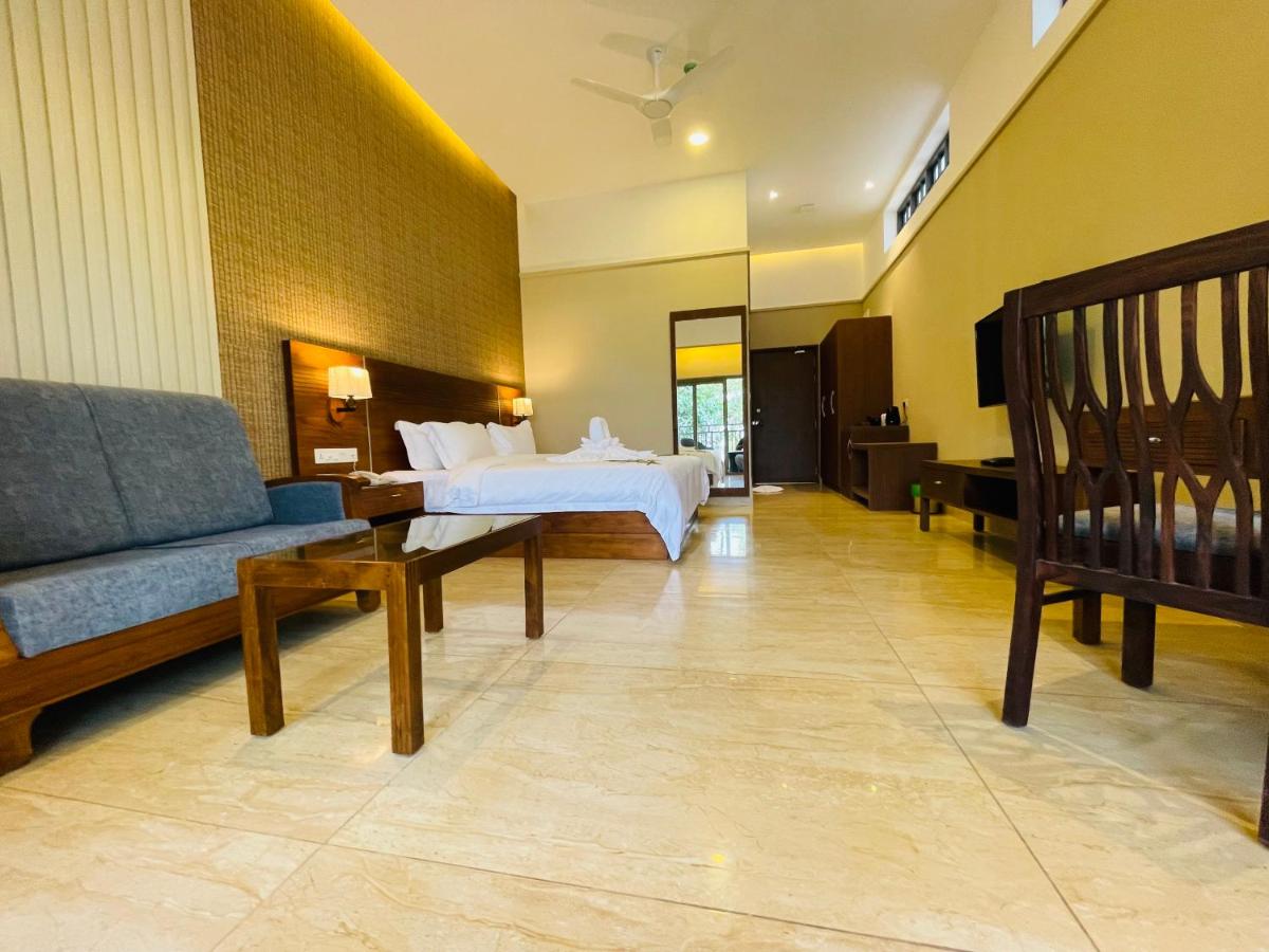 a hotel room with a bed and a couch at Elephant Passage in Munnar