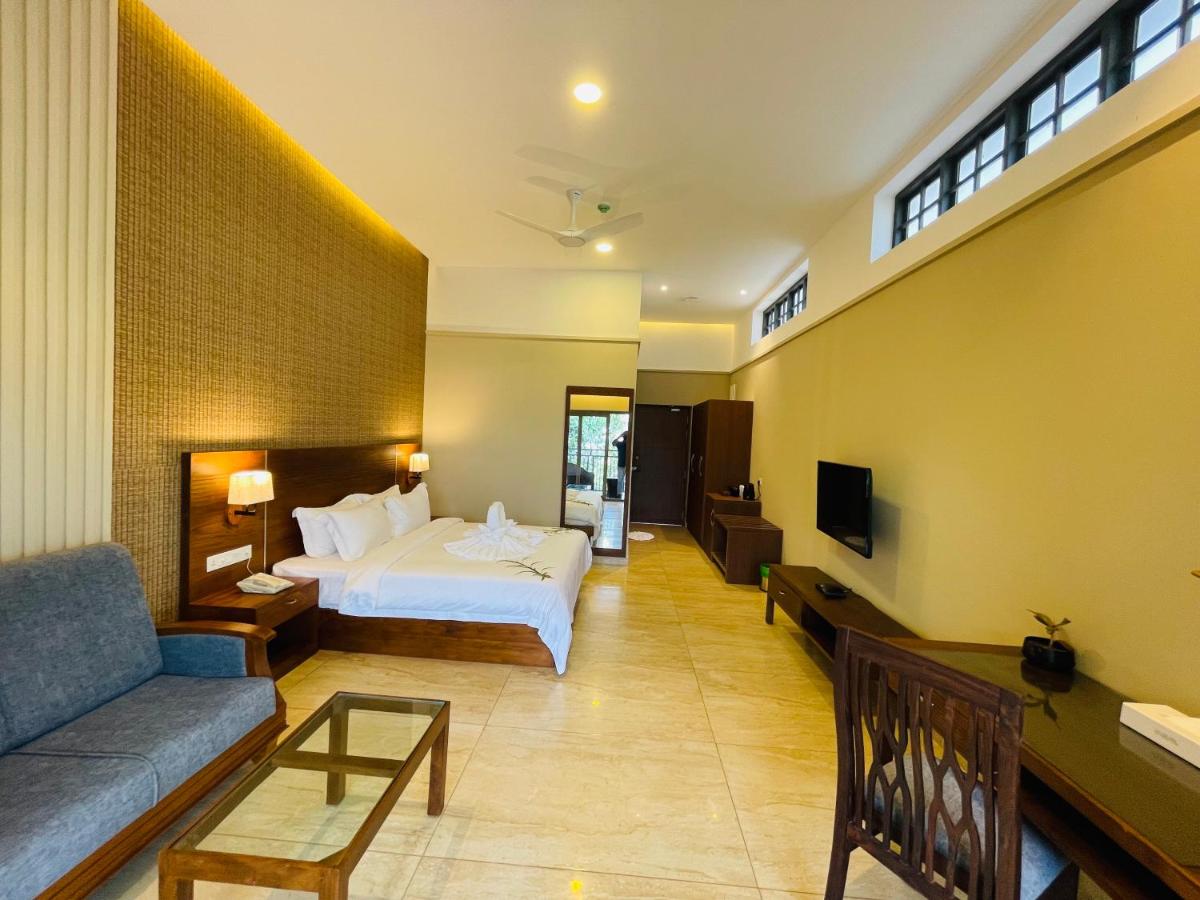 a hotel room with a bed and a couch at Elephant Passage in Munnar