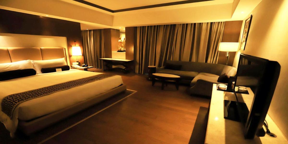 a hotel room with a bed and a couch at Crowne Plaza New Delhi Okhla by IHG in New Delhi