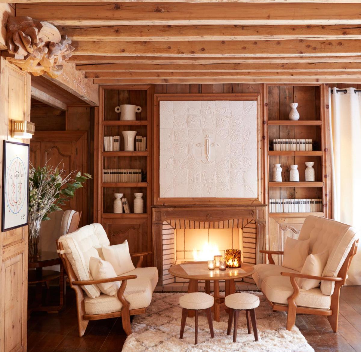 un salon avec une table et des chaises et une cheminée dans l'établissement Hotel Mont Blanc Megève, à Megève