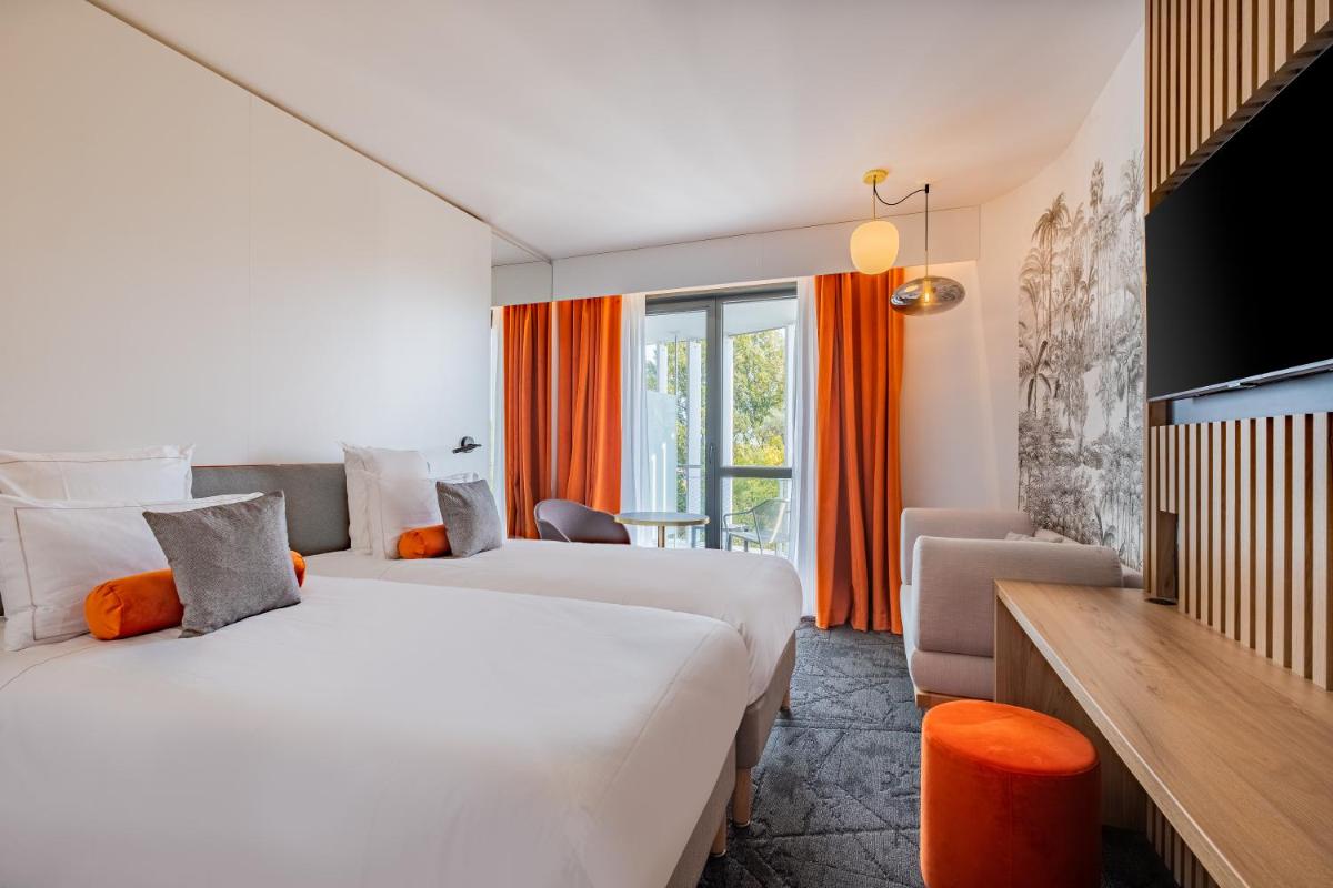 Un ou plusieurs lits dans un hébergement de l'établissement GOLDEN TULIP LYON OUEST TECHLID Hotel & Spa