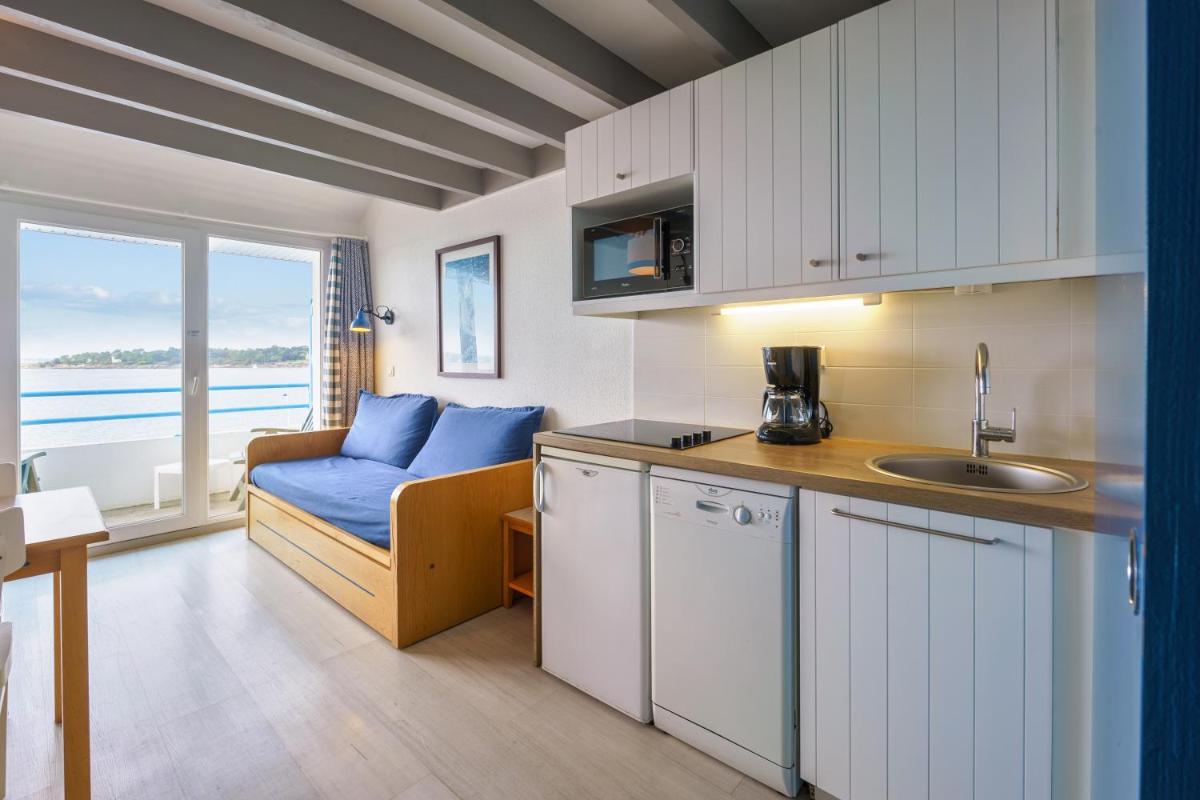 une cuisine et un salon avec un canapé et un évier dans l'établissement Résidence Pierre & Vacances la Corniche de la Plage, à Bénodet