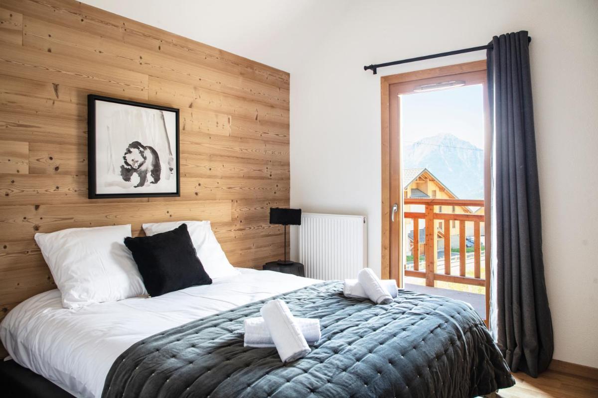 une chambre avec un lit et une grande fenêtre dans l'établissement TERRESENS - LES EDELWEISS, à Vaujany