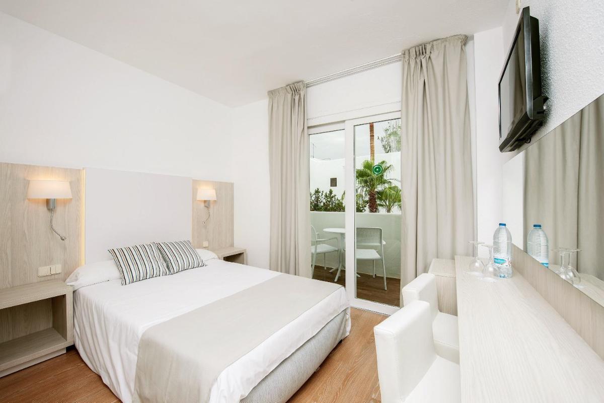 Un dormitorio blanco con una cama y una ventana. en Sentido Fido Tucan - Adults Only, en Cala d´Or