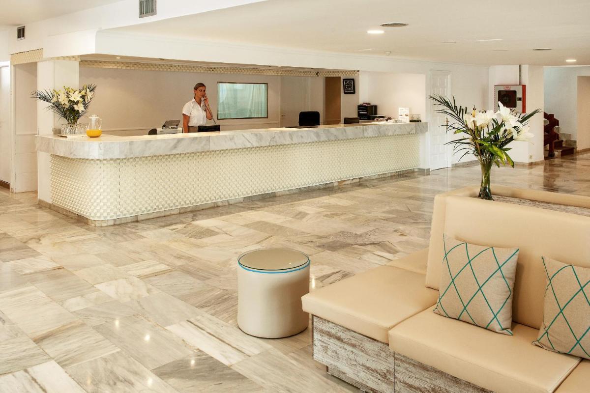una mujer parada en la recepción del vestíbulo de un hotel en Sentido Fido Tucan - Adults Only, en Cala d´Or 40 fotos más