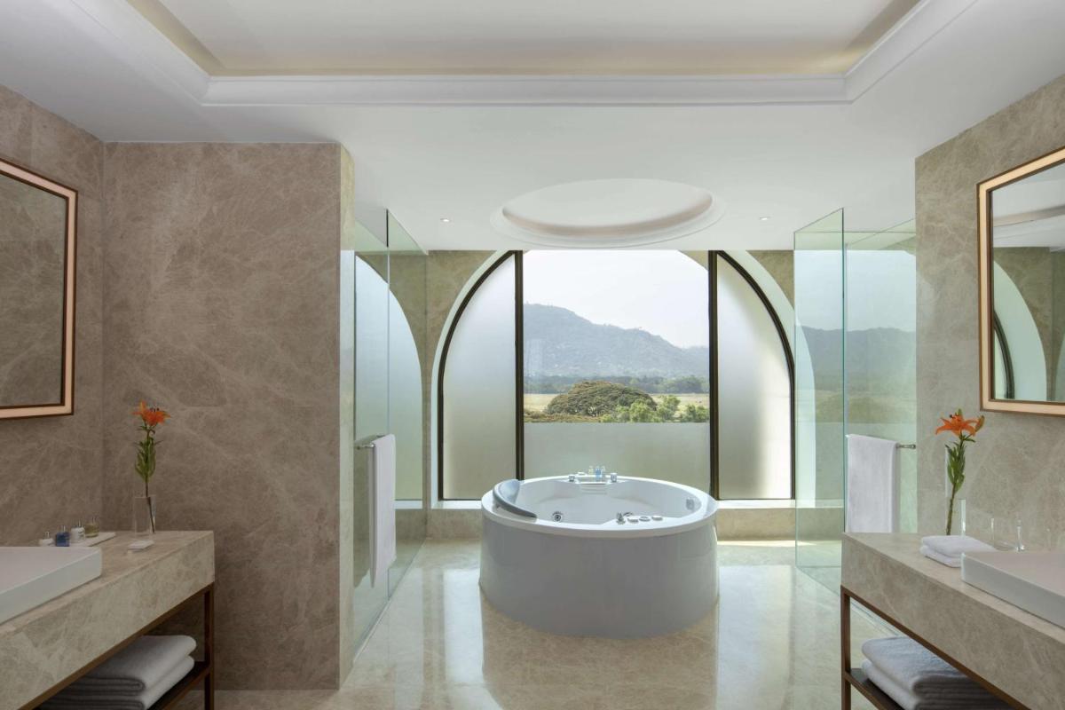 a bathroom with a tub and a large window at Radisson Blu Plaza Hotel Mysore in Mysore