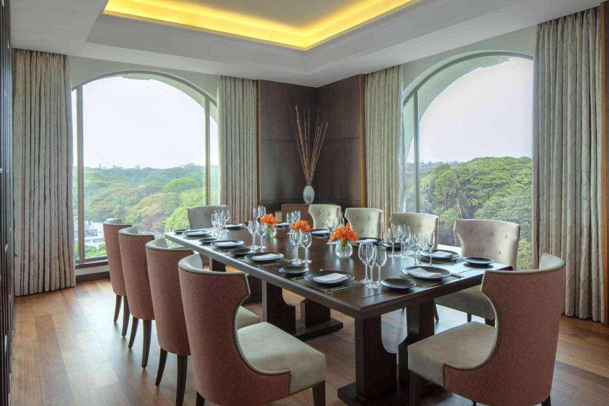 a dining room with a long table and chairs at Radisson Blu Plaza Hotel Mysore in Mysore