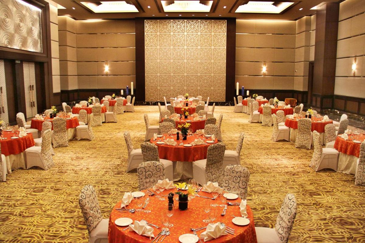 a banquet hall with tables and chairs in a room at Radisson Blu Plaza Hotel Mysore in Mysore