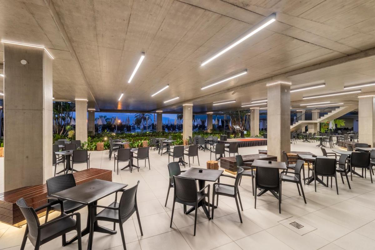 um restaurante com mesas e cadeiras em um prédio em Enotel Lido - All Inclusive no Funchal