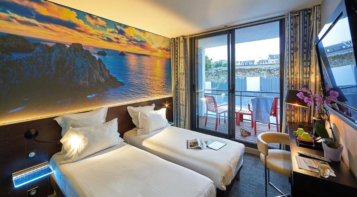 une chambre d'hôtel avec deux lits et une grande fenêtre dans l'établissement Le Thalassa Hôtel & Spa, à Camaret-sur-Mer