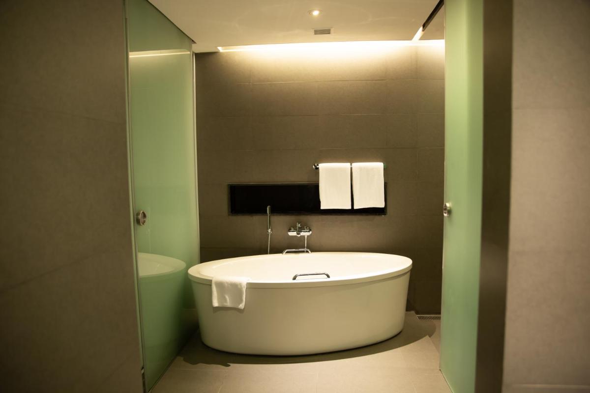 a bathroom with a white tub in a room at Novotel Kolkata Hotel and Residences in Kolkata a bathroom with a white tub in a room at Novotel Kolkata Hotel and Residences in Kolkata
