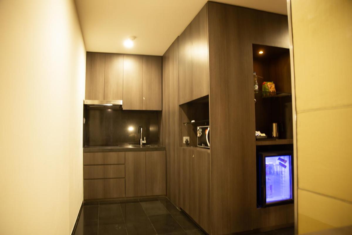 a small kitchen with wooden cabinets and a television at Novotel Kolkata Hotel and Residences in Kolkata a small kitchen with wooden cabinets and a television at Novotel Kolkata Hotel and Residences in Kolkata