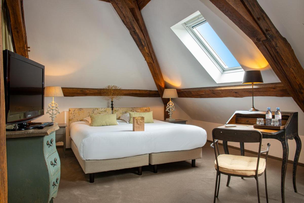 une chambre avec un lit blanc et une télévision dans l'établissement Château de Courban and Spa Nuxe, à Courban