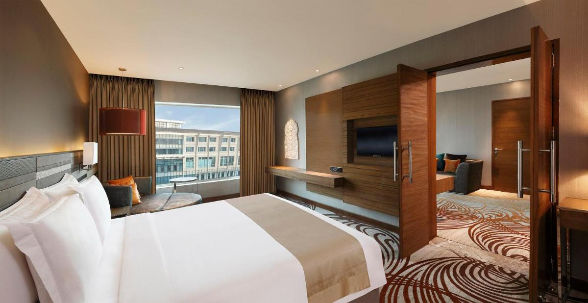 a hotel room with a bed and a television at Holiday Inn Jaipur City Centre by IHG in Jaipur +80 photos a hotel room with a bed and a television at Holiday Inn Jaipur City Centre by IHG in Jaipur +80 photos