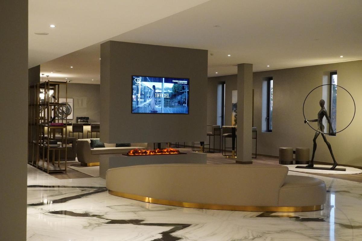 uma sala de estar com um sofá e uma TV na parede em DS Hotel Lusopark em Santa Maria da Feira