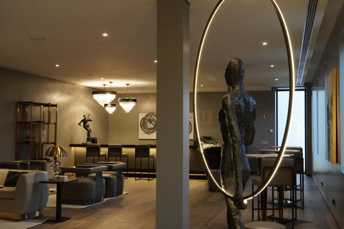 uma sala de estar com uma estátua em frente a um espelho em DS Hotel Lusopark em Santa Maria da Feira