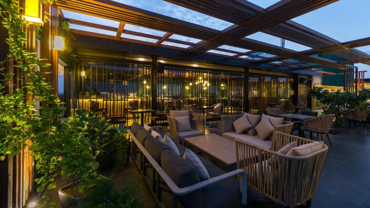 a patio with couches and tables on a building at Novotel Chennai Chamiers Road in Chennai
