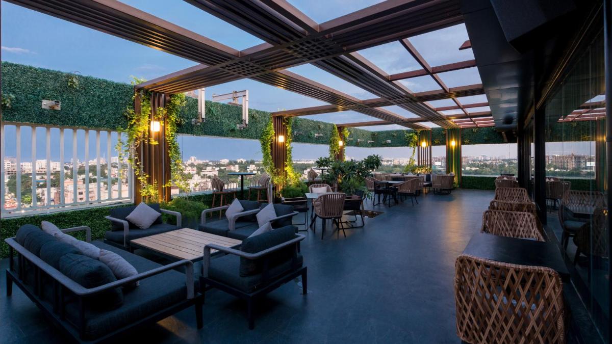 a restaurant with couches and tables on a roof at Novotel Chennai Chamiers Road in Chennai