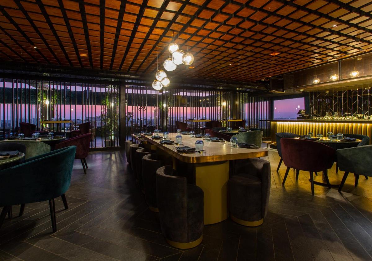a dining room with a long table and chairs at Novotel Chennai Chamiers Road in Chennai