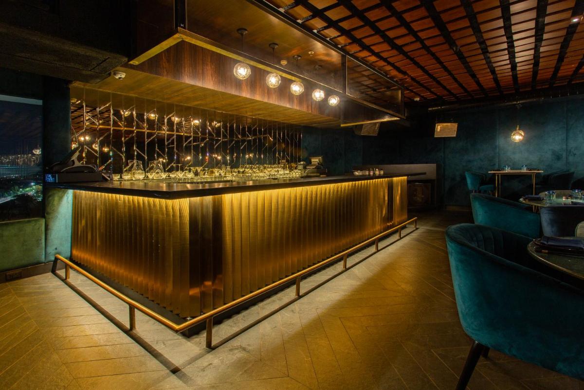a bar in a restaurant with wine glasses at Novotel Chennai Chamiers Road in Chennai