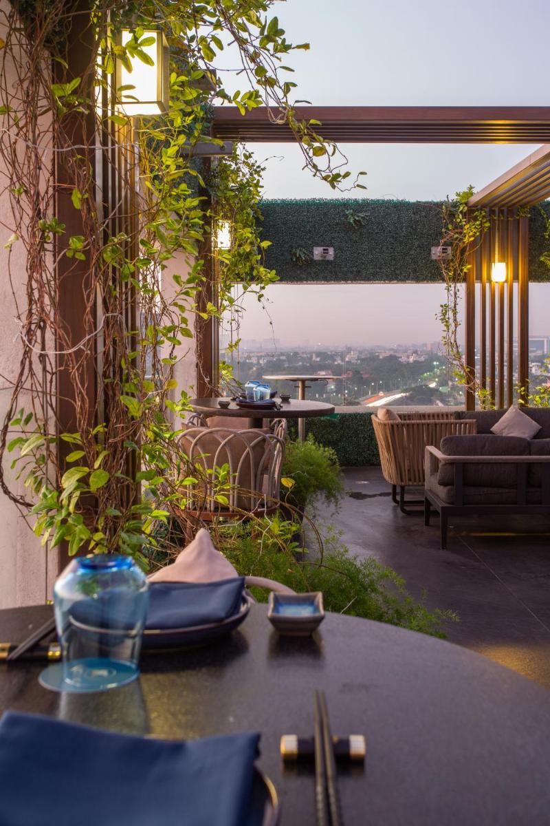 a patio with a table with a view of the city at Novotel Chennai Chamiers Road in Chennai