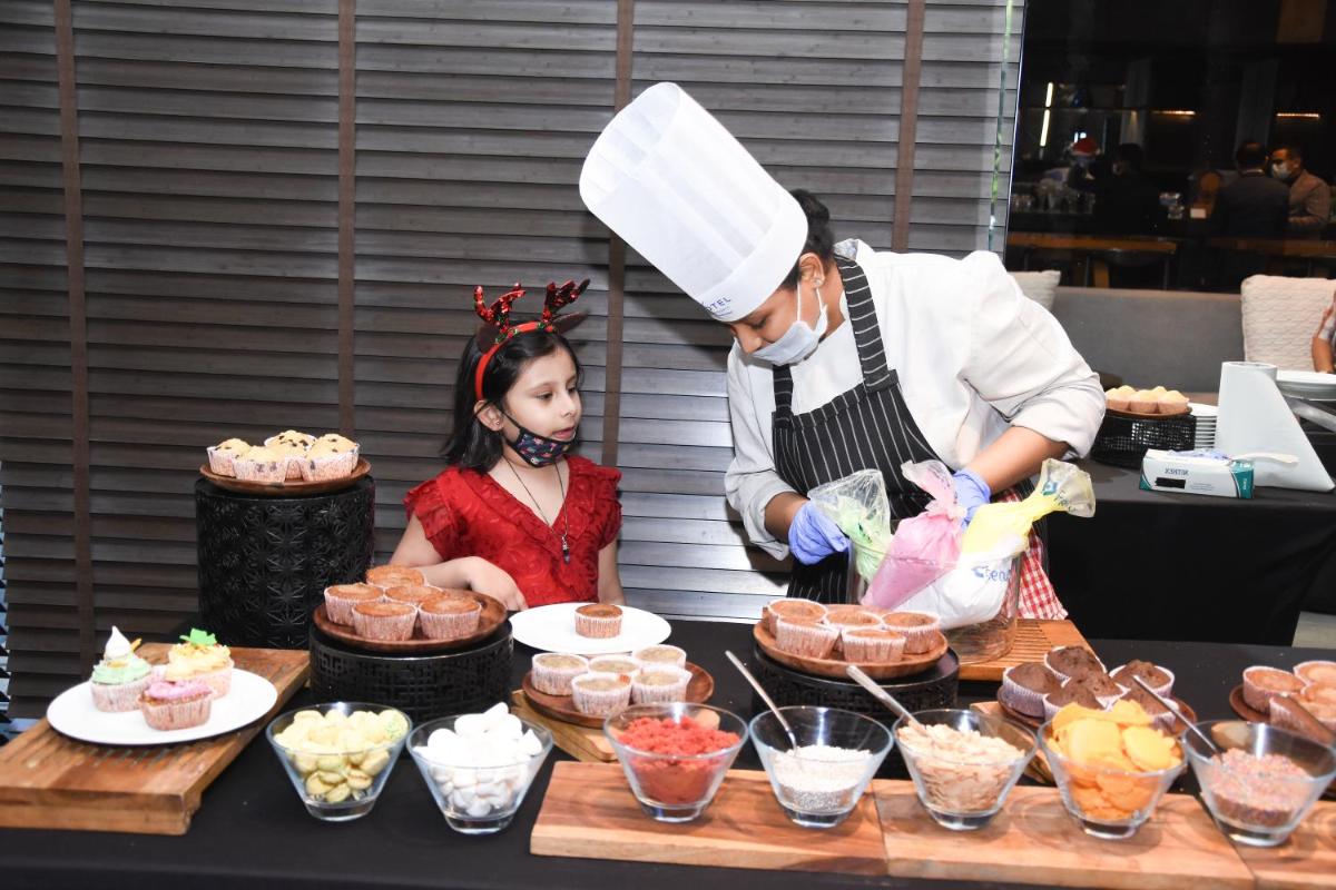 a woman and a little girl preparing food at Novotel Chennai Chamiers Road in Chennai