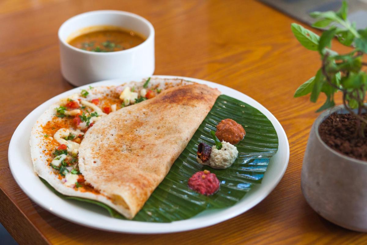 a plate with a plate of food on a table at Novotel Chennai Chamiers Road in Chennai