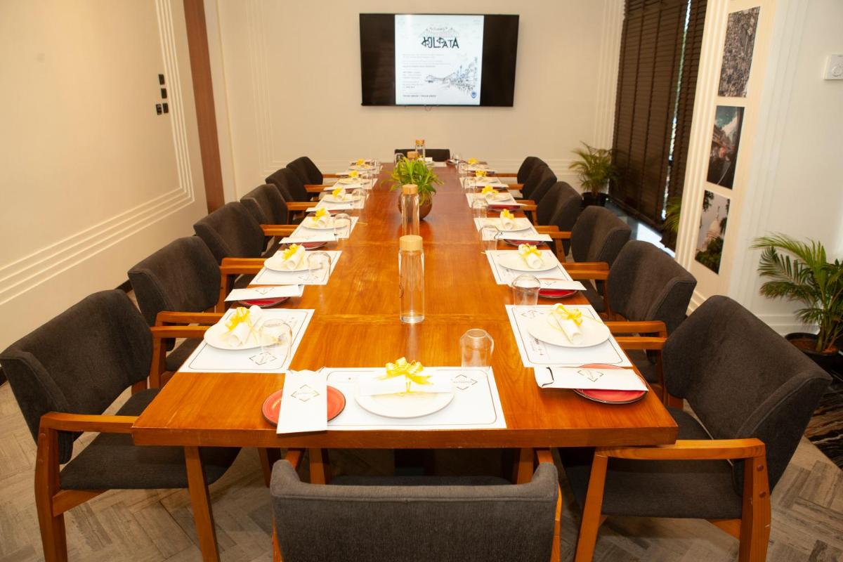 a large conference room with a long table with chairs at Novotel Chennai Chamiers Road in Chennai