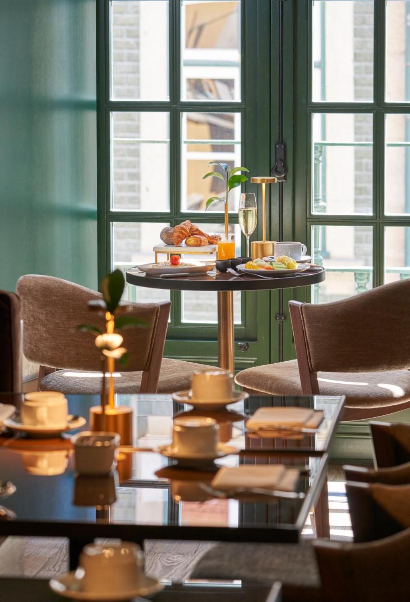 uma sala de jantar com uma mesa e cadeiras com comida nela em PortoBay Flores no Porto mais 31 fotografias