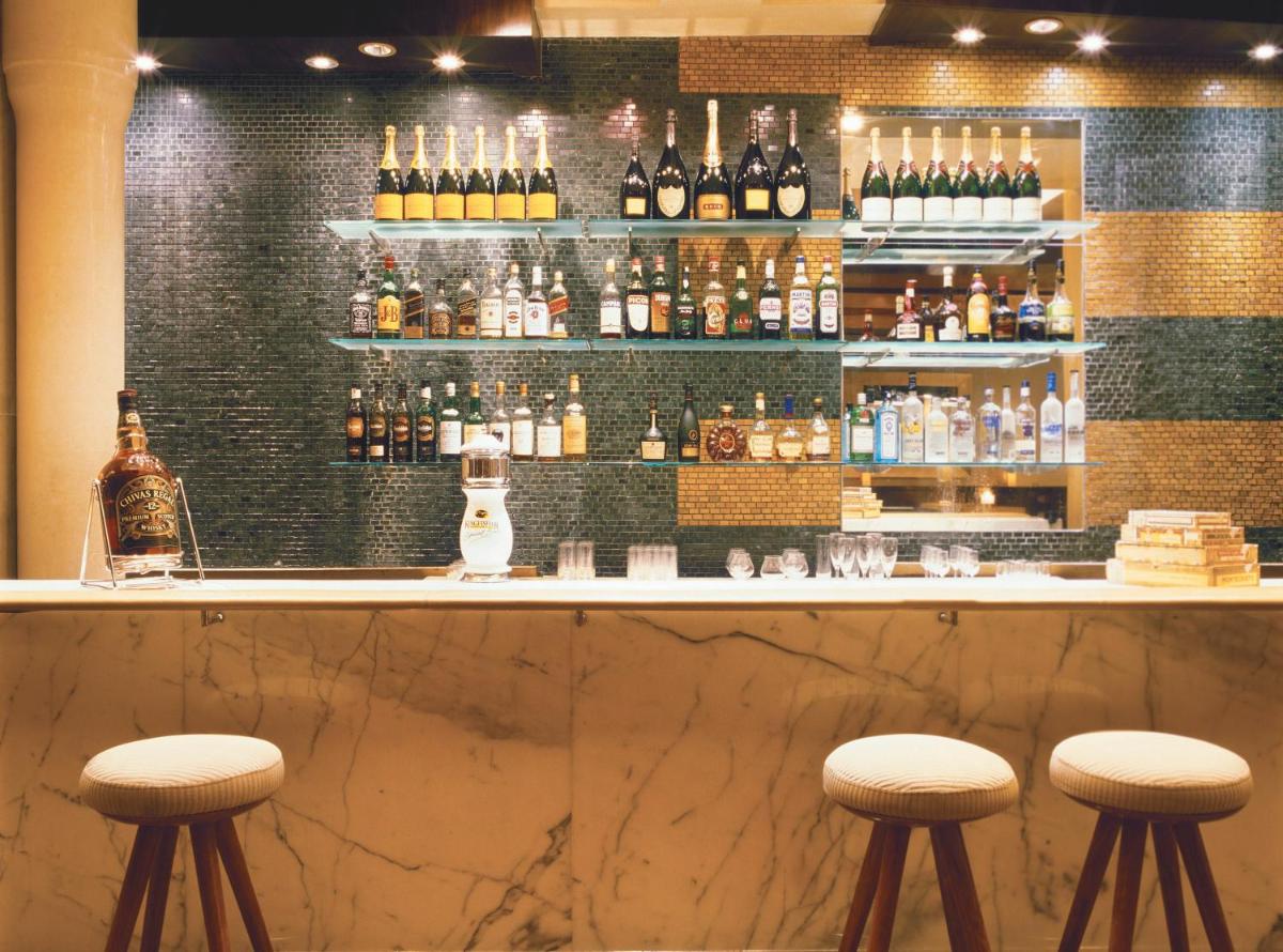 a bar with two stools in front of a counter at Trident Nariman Point in Mumbai a bar with two stools in front of a counter at Trident Nariman Point in Mumbai
