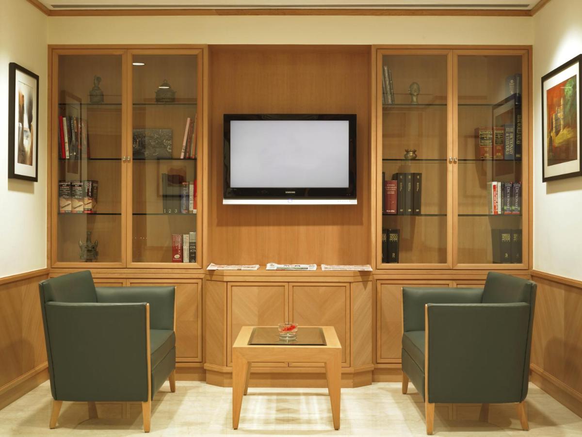 a living room with two chairs and a flat screen tv at Trident Nariman Point in Mumbai a living room with two chairs and a flat screen tv at Trident Nariman Point in Mumbai