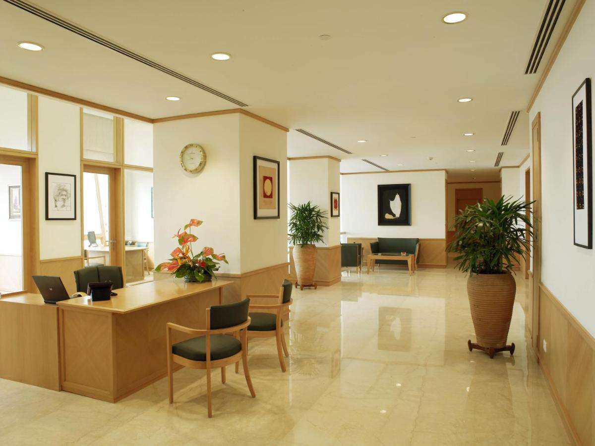 an office lobby with a reception desk and chairs at Trident Nariman Point in Mumbai an office lobby with a reception desk and chairs at Trident Nariman Point in Mumbai