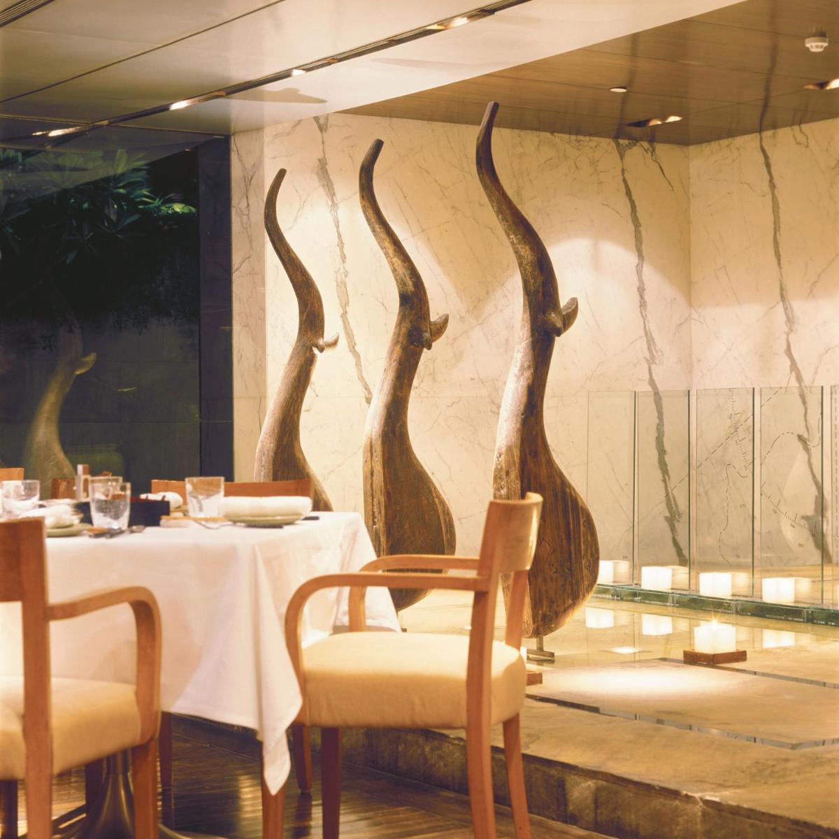 a restaurant with a table with three birds on the wall at Trident Nariman Point in Mumbai a restaurant with a table with three birds on the wall at Trident Nariman Point in Mumbai
