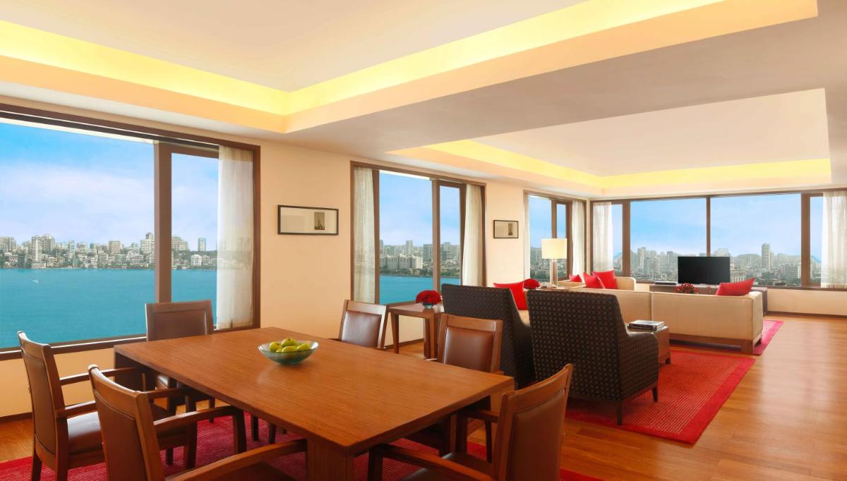 a dining room with a table and chairs and a couch at Trident Nariman Point in Mumbai a dining room with a table and chairs and a couch at Trident Nariman Point in Mumbai