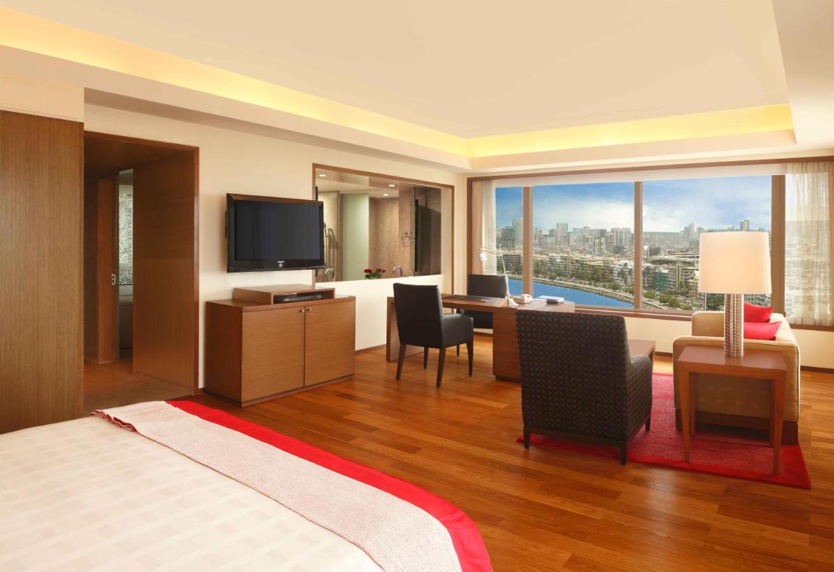 a hotel room with a bed and a desk and a television at Trident Nariman Point in Mumbai a hotel room with a bed and a desk and a television at Trident Nariman Point in Mumbai