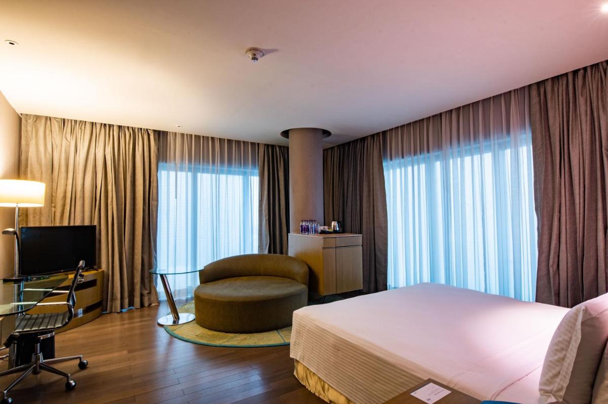 a hotel room with a bed and a chair and a desk at Holiday Inn New Delhi Aerocity by IHG in New Delhi