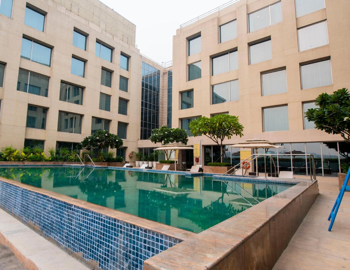 a swimming pool in front of a building at Holiday Inn New Delhi Aerocity by IHG in New Delhi
