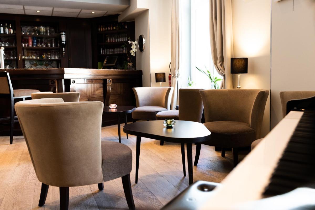 un bar avec des chaises et des tables et un piano dans l'établissement Hotel Regina & Spa, à Berck-sur-Mer