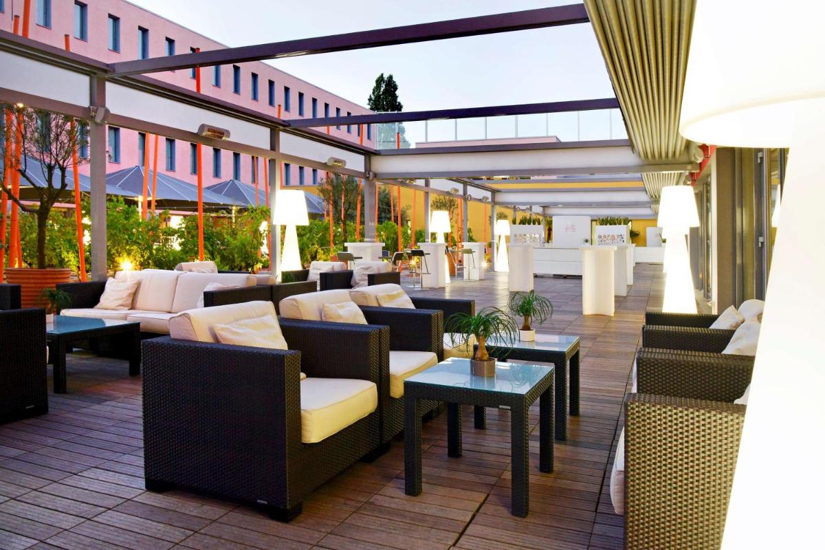 un patio avec des canapés et des tables dans un bâtiment dans l'établissement Radisson Blu Hotel Toulouse Airport, à Blagnac