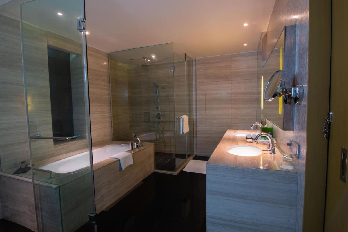a bathroom with a tub and a sink and a shower at Holiday Inn New Delhi Aerocity by IHG in New Delhi